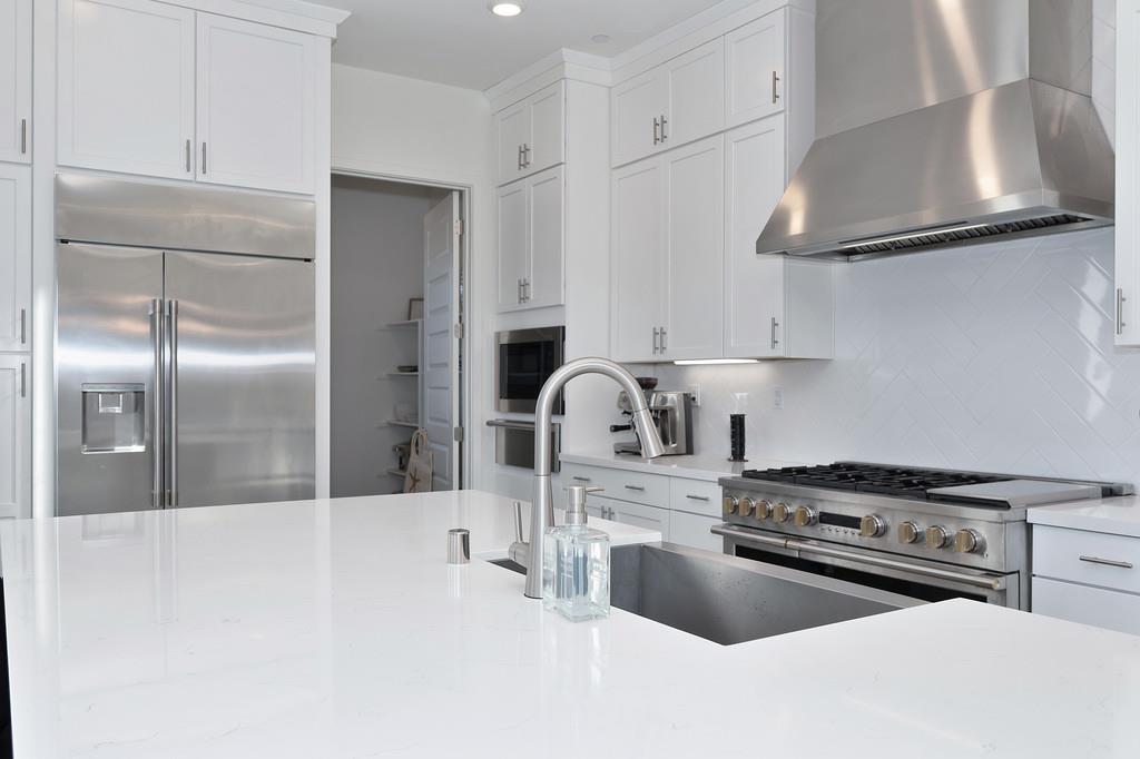 3063 Sherman Way El Dorado Hills, CA 95762 - Photo 17 of 75 a kitchen with kitchen island a stove a sink and cabinets
