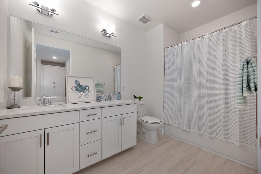 3063 Sherman Way El Dorado Hills, CA 95762 - Photo 34 of 75 a bathroom with a double vanity sink toilet and a mirror