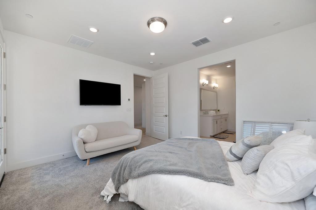 3063 Sherman Way El Dorado Hills, CA 95762 - Photo 39 of 75 a bedroom with a bed a couch and a flat screen tv