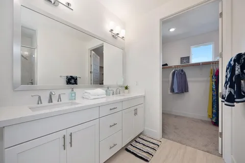 a view of a house with a small yard plants and a large tree