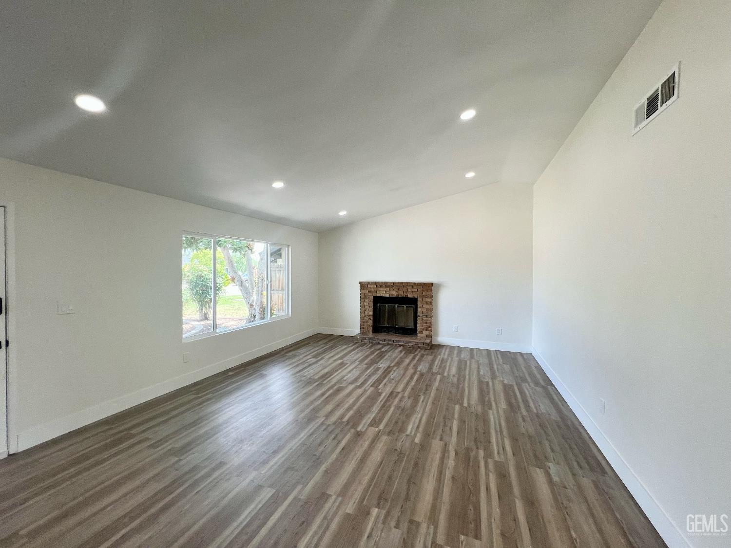 Undisclosed Address Bakersfield, CA 93308 - Photo 4 of 23 a view of empty room with wooden floor and fireplace