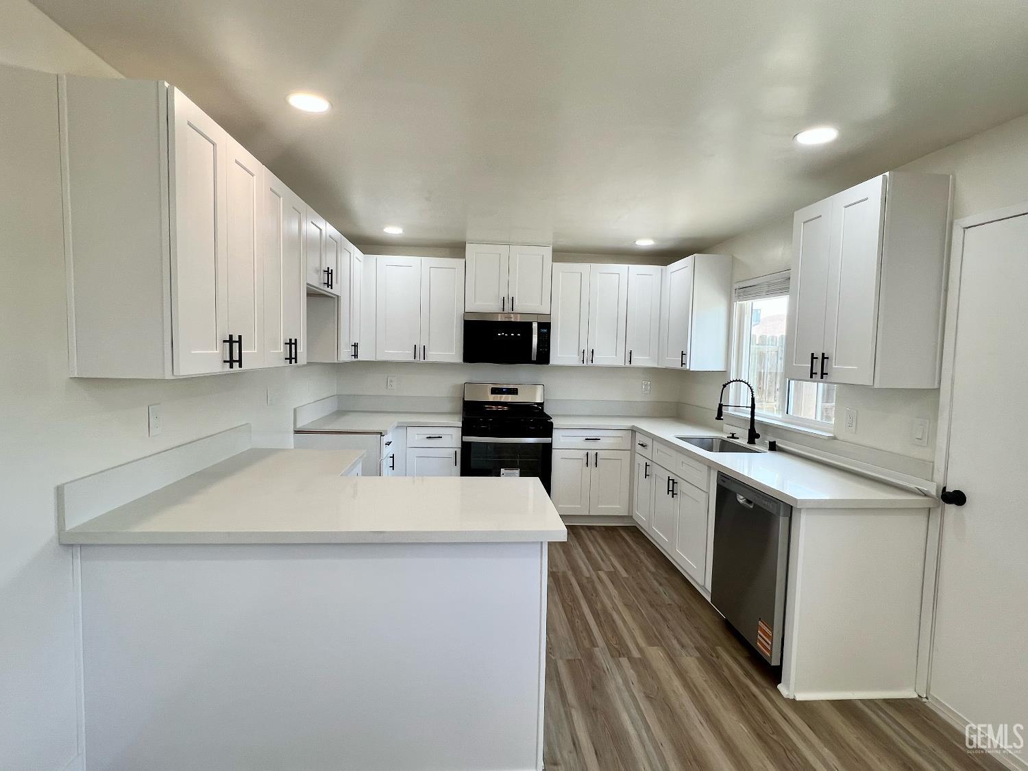 Undisclosed Address Bakersfield, CA 93308 - Photo 7 of 23 a kitchen with granite countertop white cabinets and white stainless steel appliances