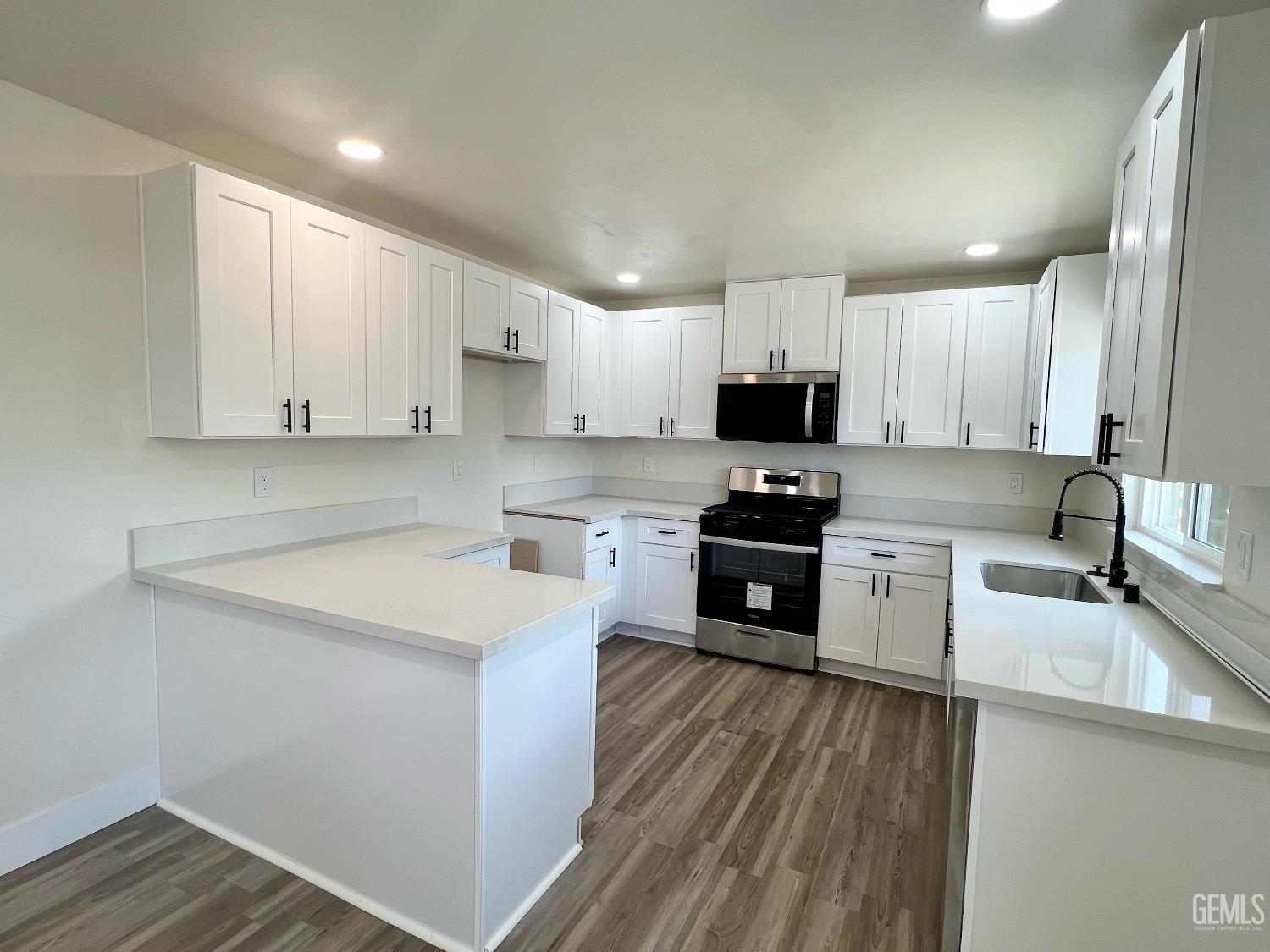 Undisclosed Address Bakersfield, CA 93308 - Photo 9 of 23 a kitchen with granite countertop white cabinets and stainless steel appliances