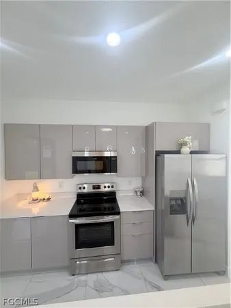 a kitchen with a refrigerator and a stove top oven