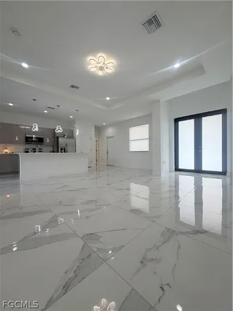 a view of a hall with kitchen and living room