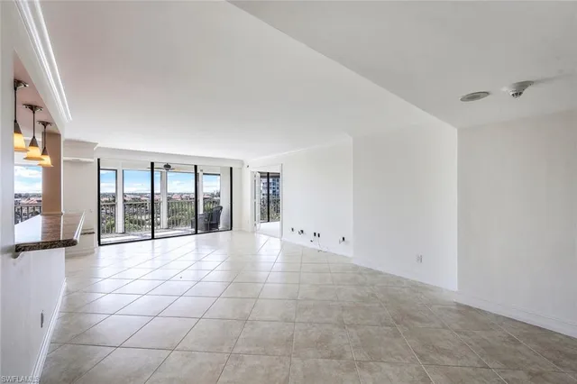 a big room with windows and chandelier fan
