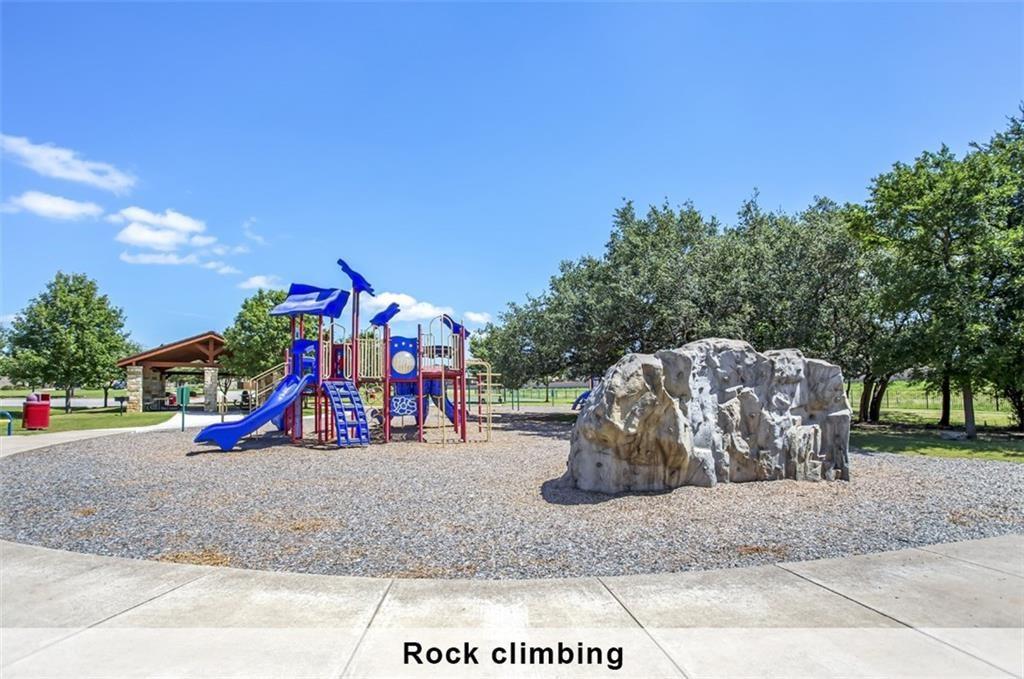 2109 Granite Springs Road Leander, TX 78641 - Photo 22 of 30 A vibrant playground featuring a rock climbing structure and playset promises endless outdoor enjoyment.