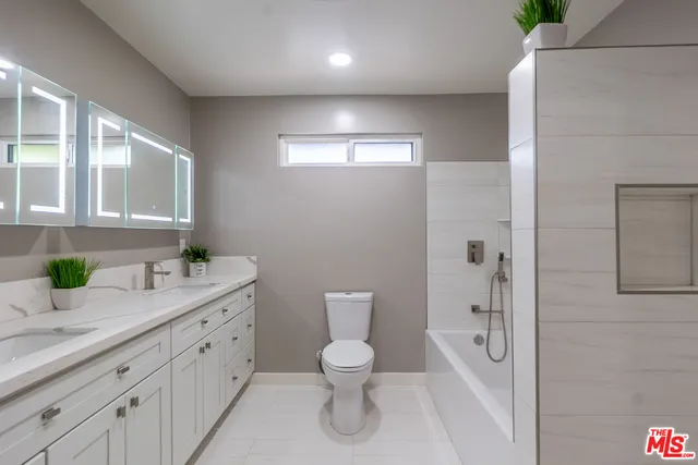 a bathroom with a granite countertop sink a toilet and shower