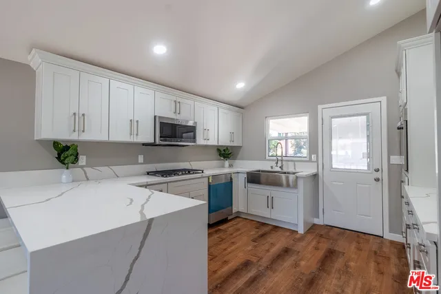 a kitchen with white cabinets and white appliances