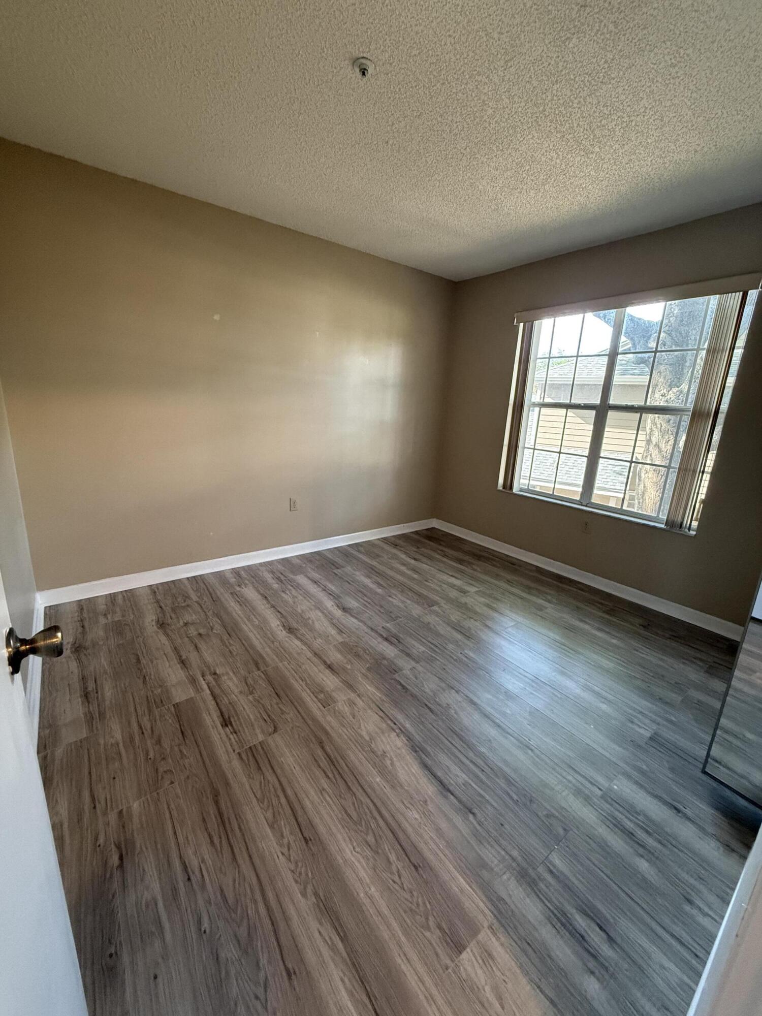 683 Post Oak Circle, Unit 105 Altamonte Springs, FL 32701 - Photo 11 of 22 an empty room with wooden floor and windows