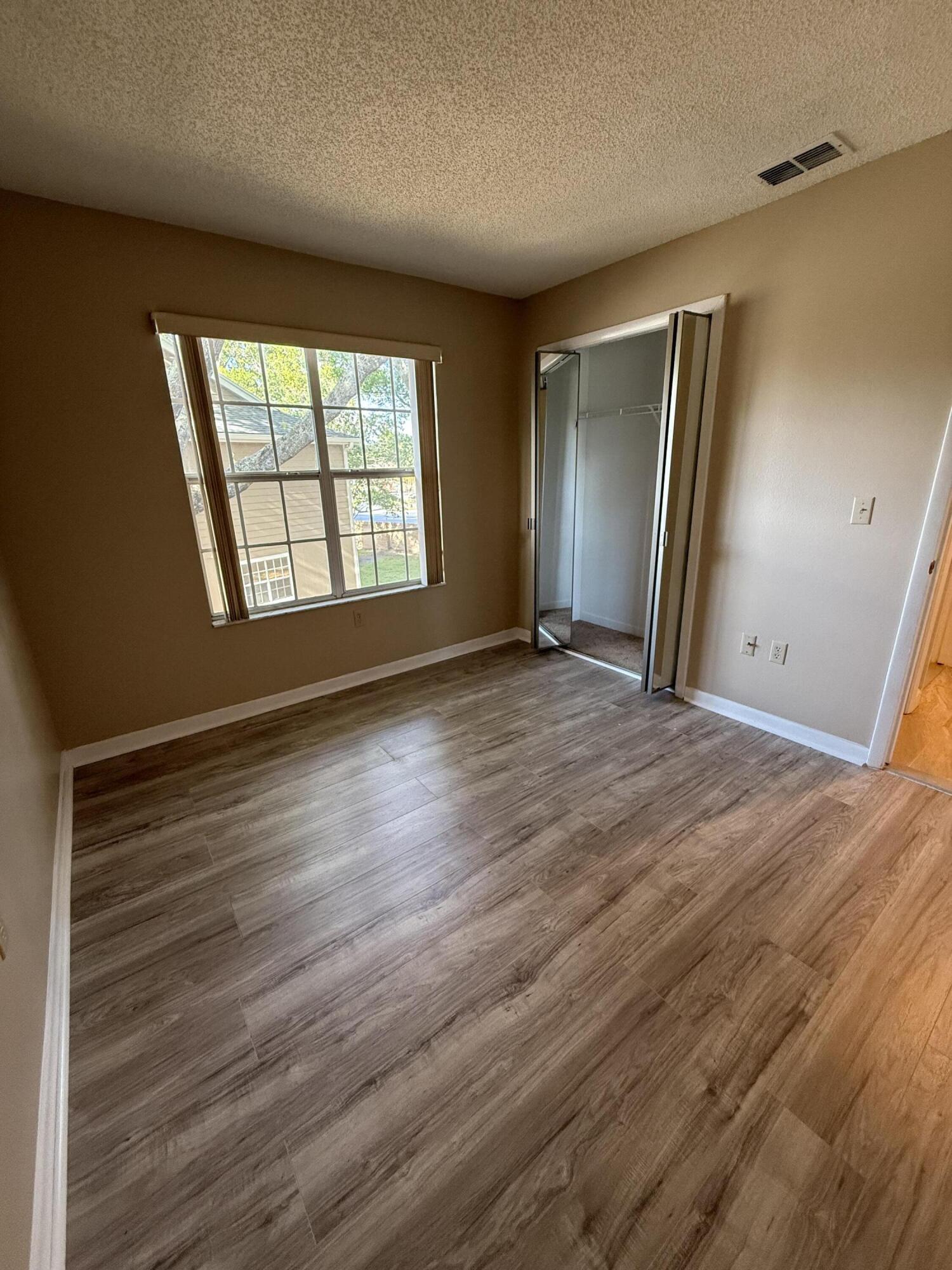 683 Post Oak Circle, Unit 105 Altamonte Springs, FL 32701 - Photo 12 of 22 a view of an empty room with wooden floor and a window