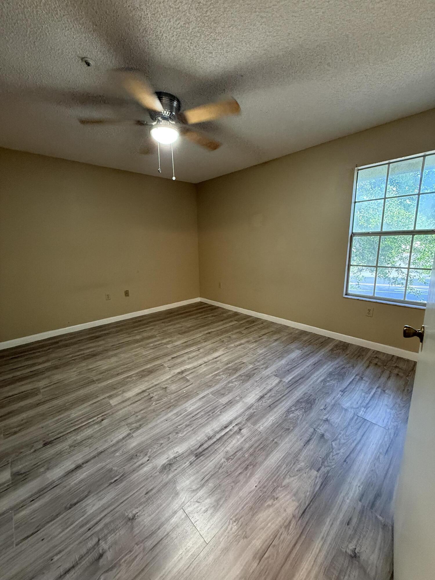 683 Post Oak Circle, Unit 105 Altamonte Springs, FL 32701 - Photo 16 of 22 an empty room with wooden floor and windows