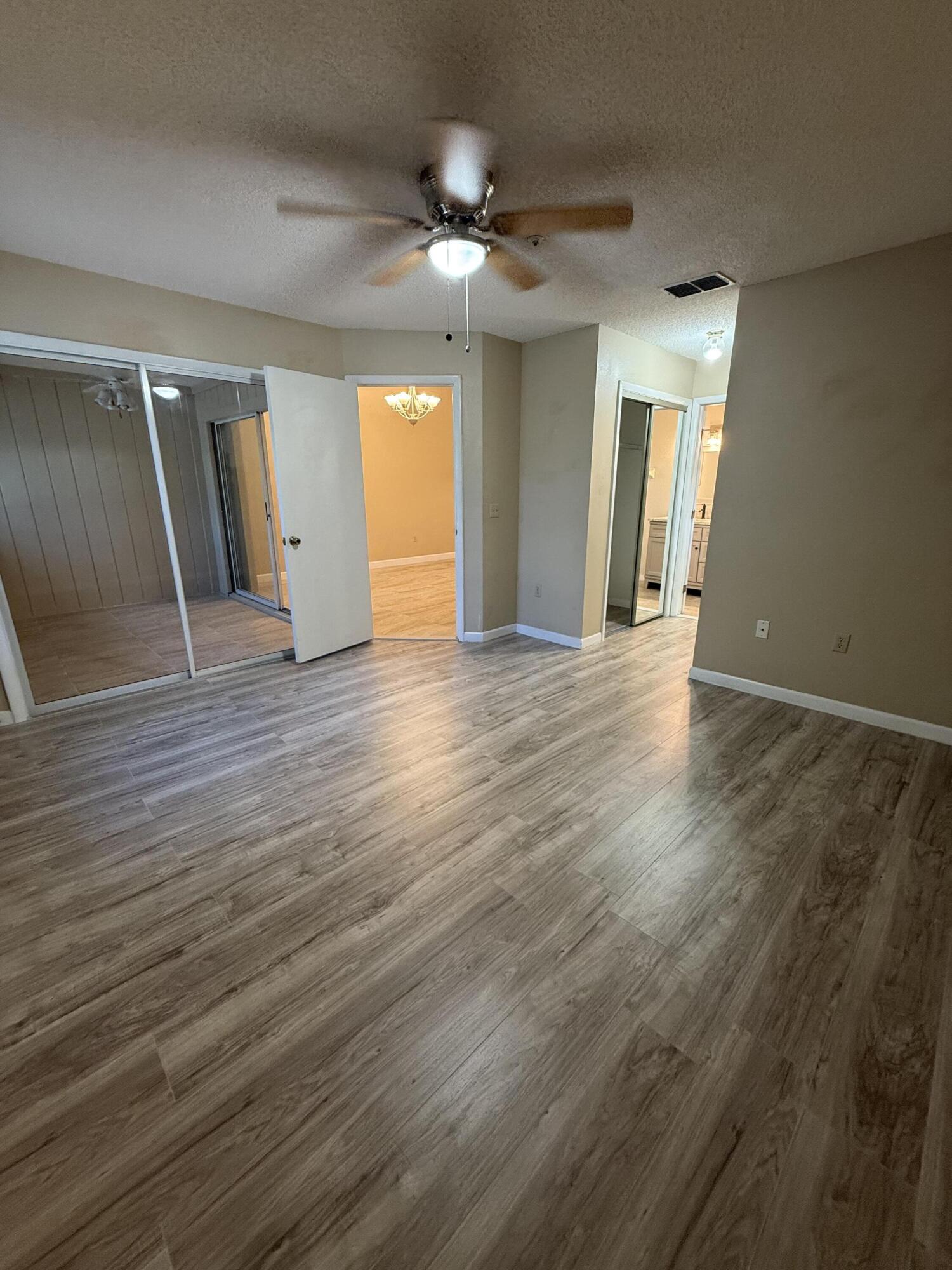 683 Post Oak Circle, Unit 105 Altamonte Springs, FL 32701 - Photo 17 of 22 a view of an empty room with window and wooden floor