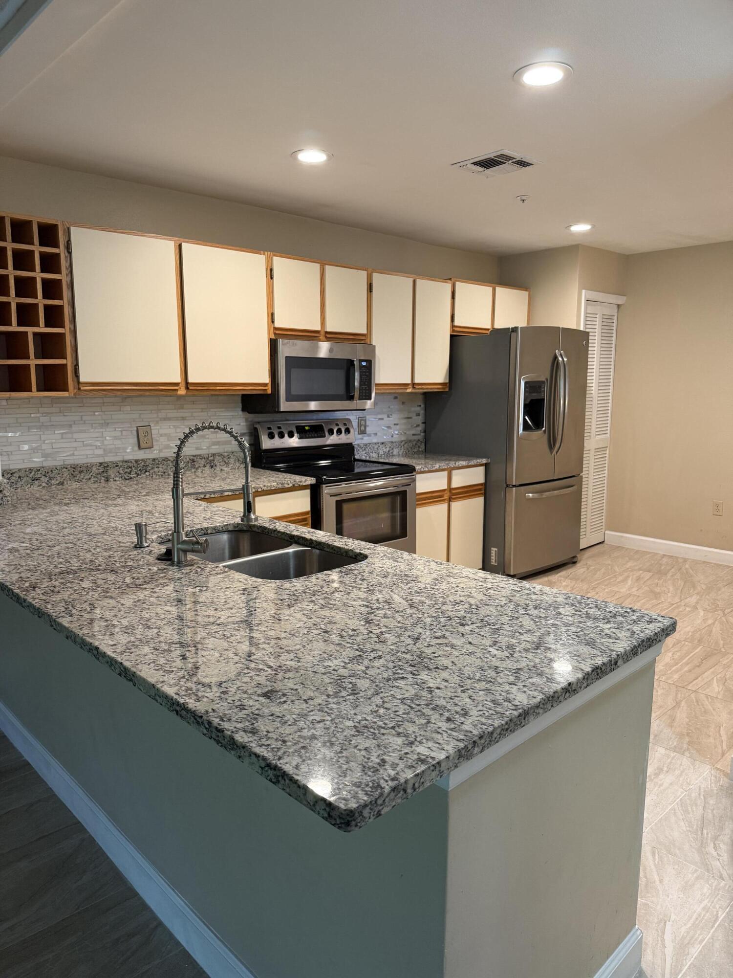 683 Post Oak Circle, Unit 105 Altamonte Springs, FL 32701 - Photo 3 of 22 a kitchen with stainless steel appliances granite countertop a sink stove and refrigerator