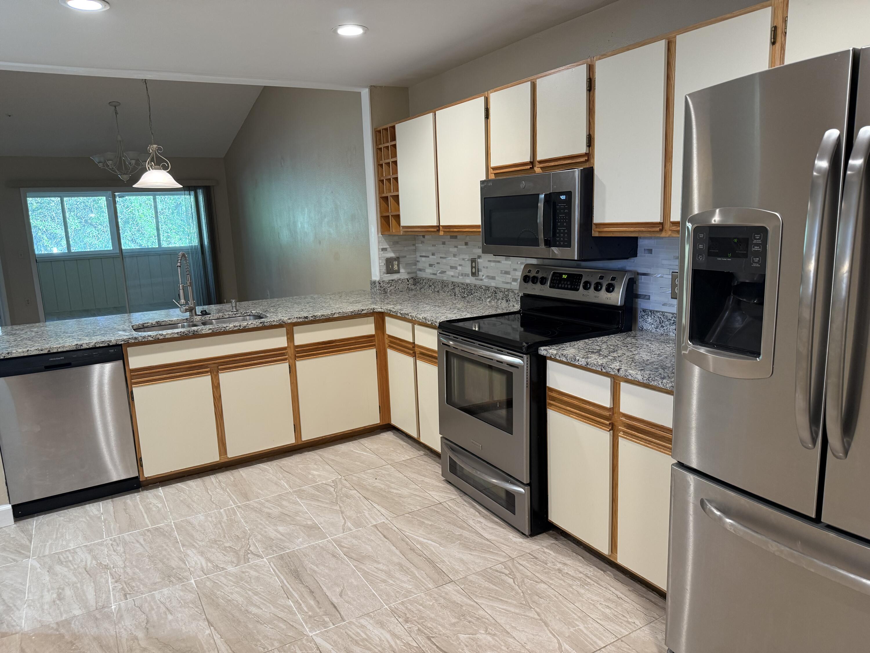 683 Post Oak Circle, Unit 105 Altamonte Springs, FL 32701 - Photo 7 of 22 a kitchen with stainless steel appliances granite countertop a stove a sink dishwasher a refrigerator and a microwave