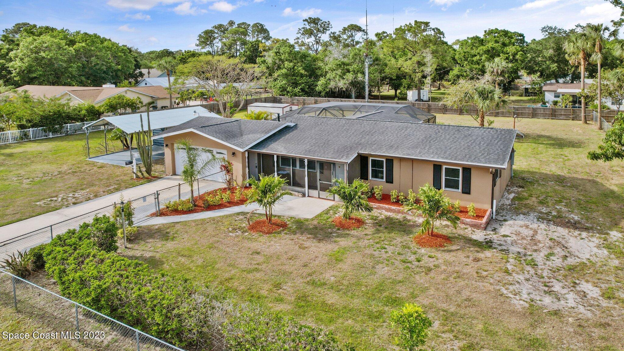 3030 Hield Road Melbourne, FL 32904 - Photo 1 of 36 a view of a house with backyard porch and sitting area