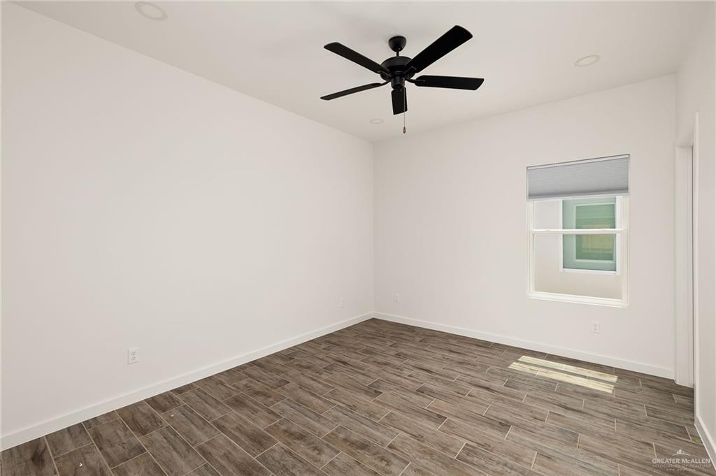 2608 Robin Road Weslaco, TX 78596 - Photo 11 of 14 an empty room with wooden floor and windows
