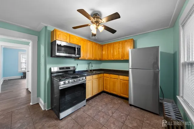 a kitchen with stainless steel appliances granite countertop a refrigerator a stove top oven a sink and dishwasher