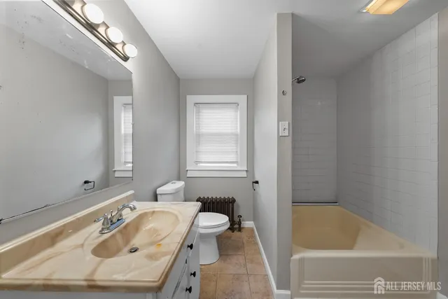 a bathroom with a tub a sink and a window