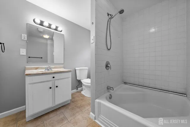 a bathroom with a granite countertop sink a toilet and shower