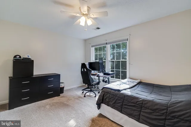 a bedroom with a bed window and a desk