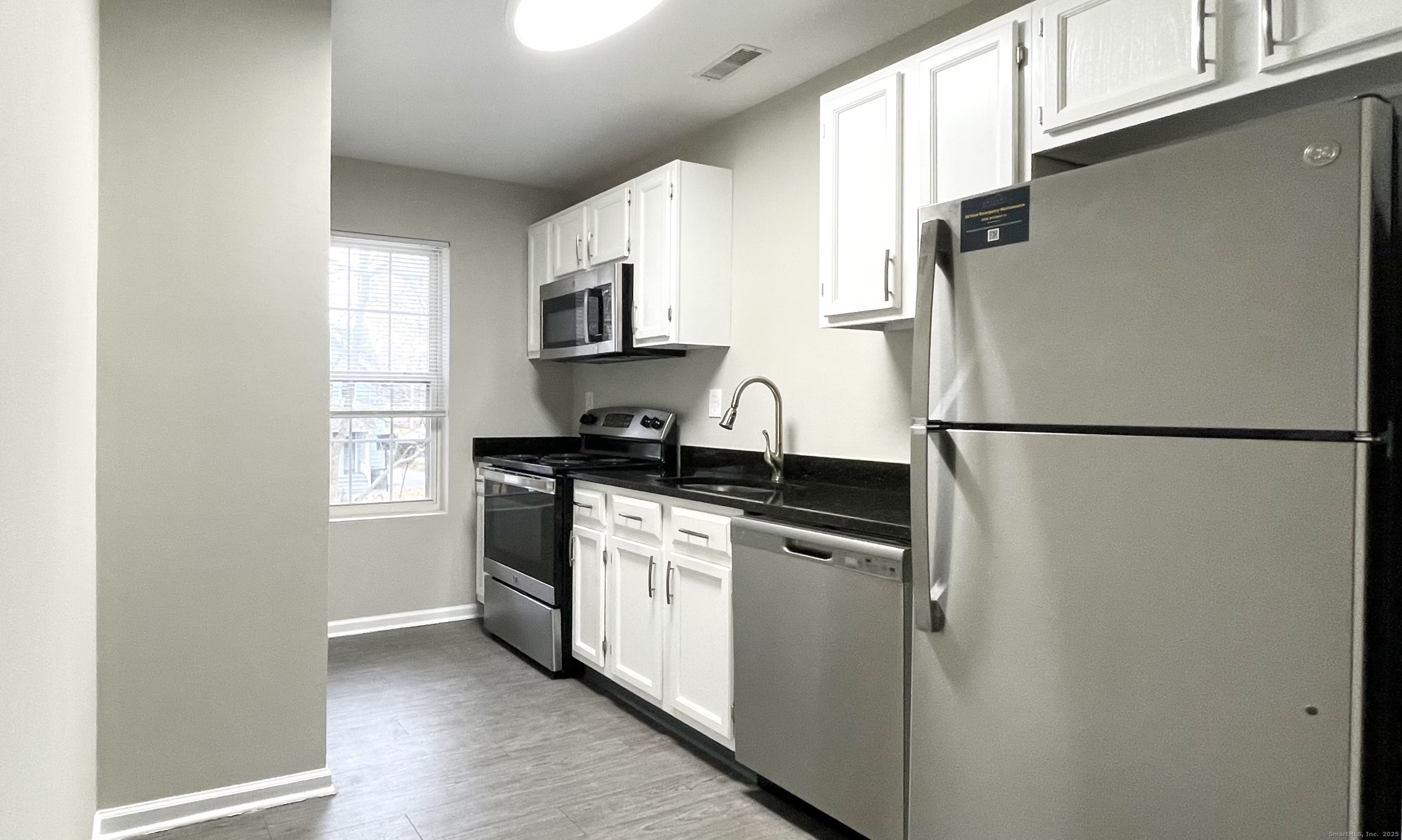 68 West Main Street Milford, CT 06460 - Photo 6 of 13 a kitchen with stainless steel appliances granite countertop a refrigerator a sink a stove a microwave a sink and cabinets