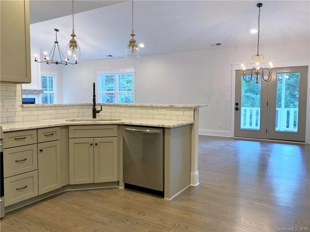 1501 Sierra Road York, SC 29745 - Photo 12 of 47 a kitchen with kitchen island a sink dishwasher and a fireplace with wooden floor