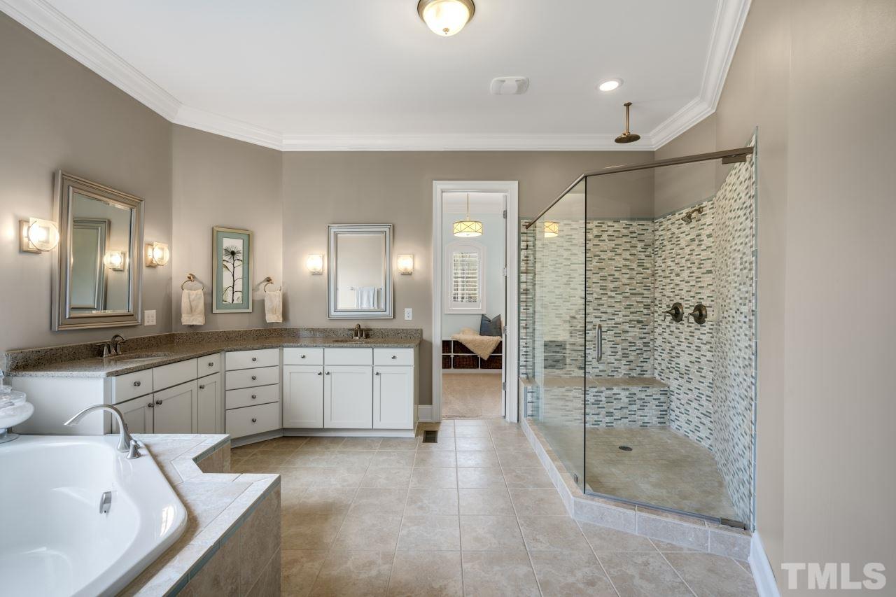 12212 Kyle Abbey Lane Raleigh, NC 27613 - Photo 18 of 30 a large bathroom with a sink mirror and a bath tub