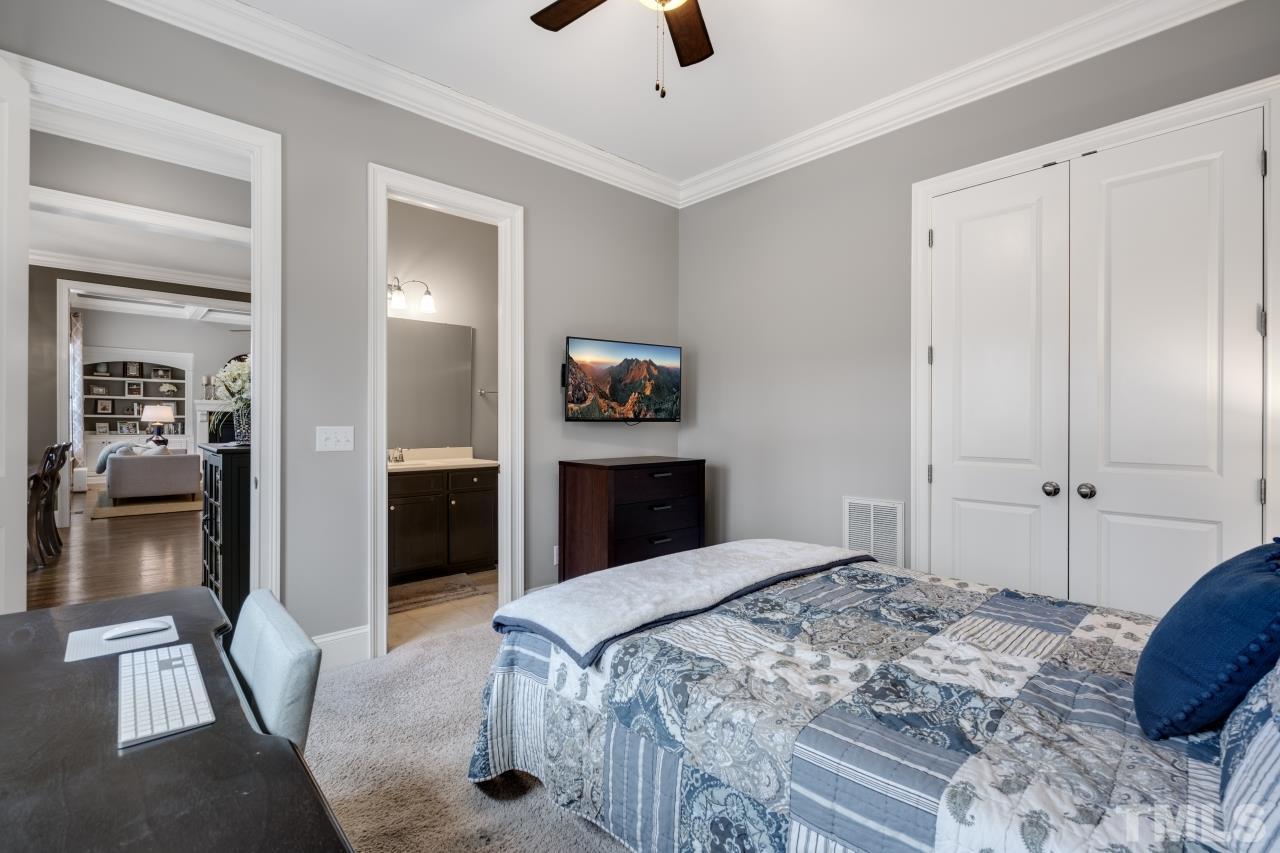12212 Kyle Abbey Lane Raleigh, NC 27613 - Photo 21 of 30 a bedroom with a large bed and a chandelier