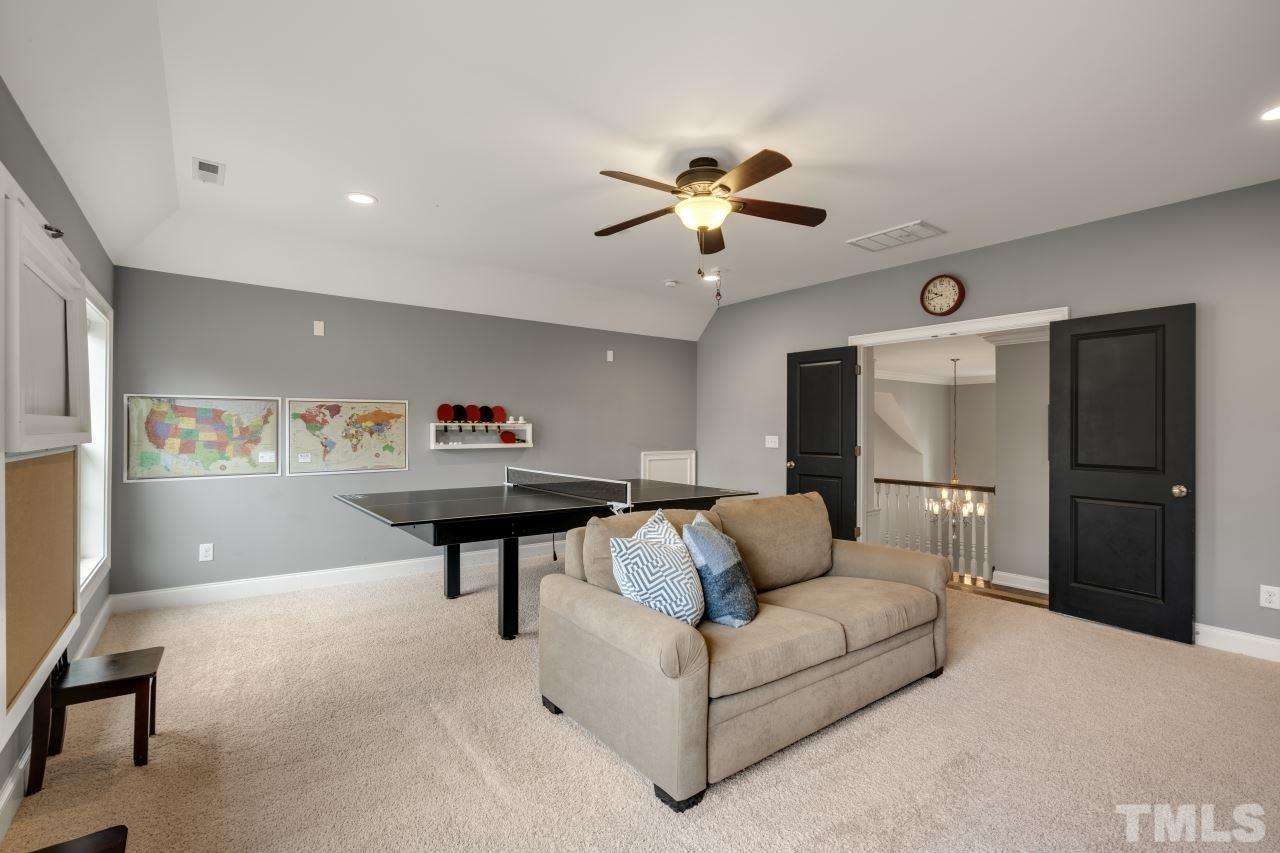 12212 Kyle Abbey Lane Raleigh, NC 27613 - Photo 24 of 30 a living room with furniture and a chandelier