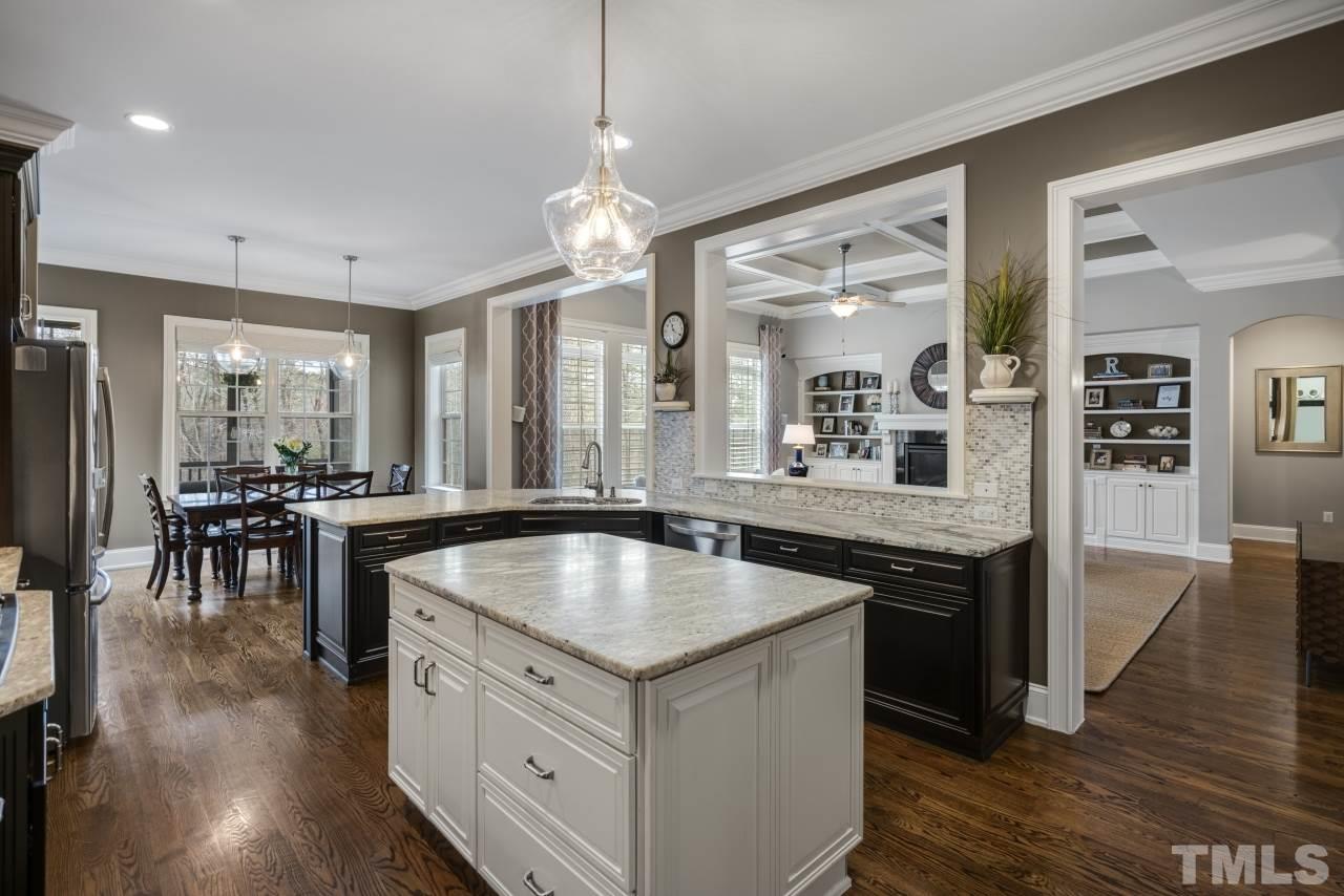 12212 Kyle Abbey Lane Raleigh, NC 27613 - Photo 10 of 30 a kitchen with center island table and stainless steel appliances