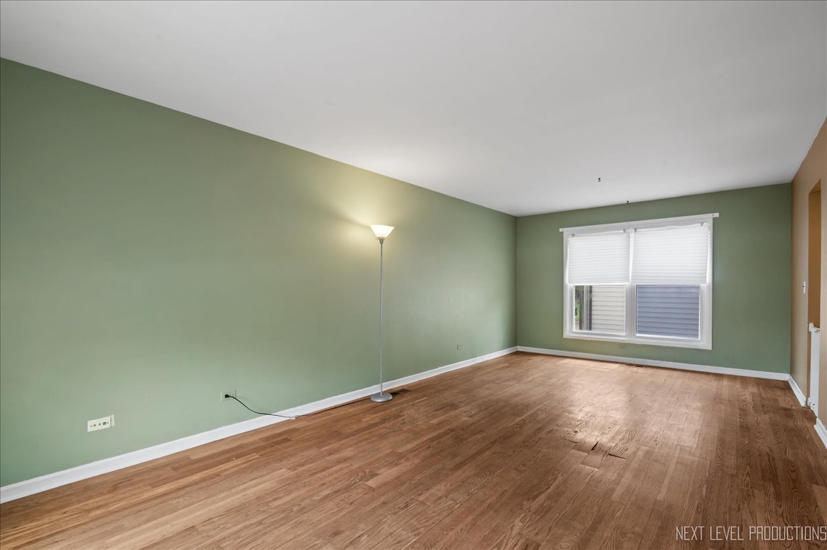 515 Hillcrest Boulevard Hoffman Estates, IL 60169 - Photo 2 of 29 an empty room with wooden floor and windows