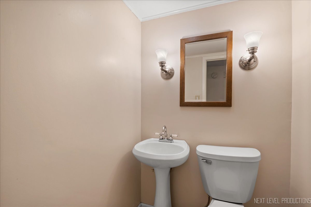 515 Hillcrest Boulevard Hoffman Estates, IL 60169 - Photo 23 of 29 a bathroom with a toilet sink and mirror