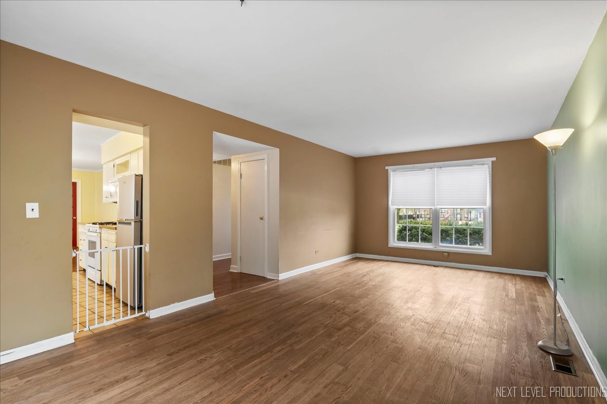515 Hillcrest Boulevard Hoffman Estates, IL 60169 - Photo 3 of 29 a view of an empty room with wooden floor and a window