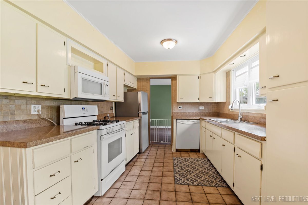 515 Hillcrest Boulevard Hoffman Estates, IL 60169 - Photo 7 of 29 a kitchen with white cabinets appliances and a sink