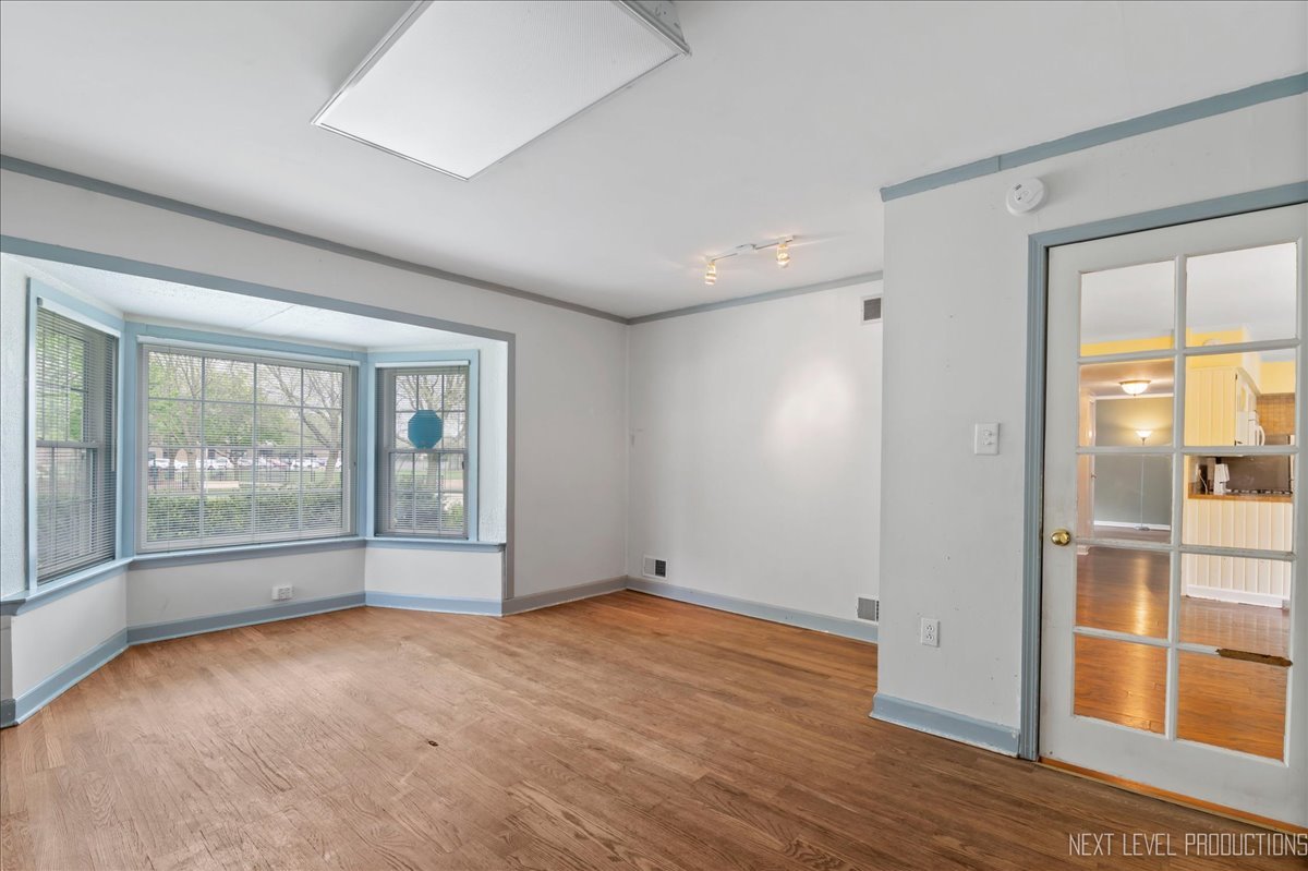 515 Hillcrest Boulevard Hoffman Estates, IL 60169 - Photo 8 of 29 an empty room with wooden floor and windows