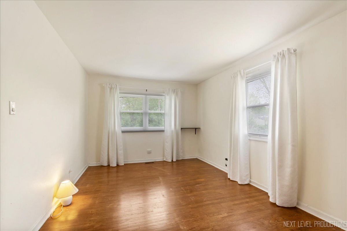 515 Hillcrest Boulevard Hoffman Estates, IL 60169 - Photo 10 of 29 an empty room with wooden floor and windows