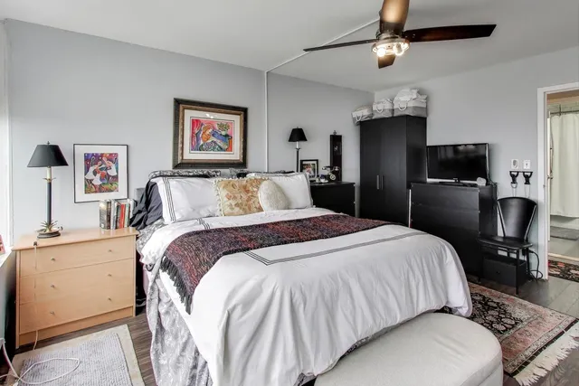 a bedroom with a bed and wooden floor