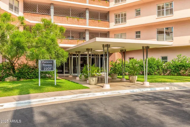 a view of a building with a yard and plants