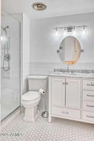 a bathroom with a granite countertop toilet a sink and a mirror