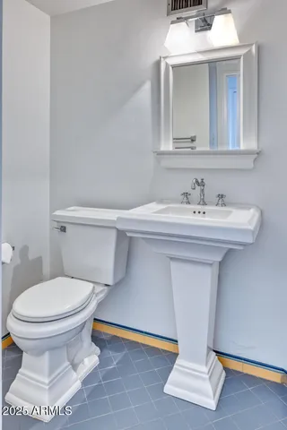 a bathroom with a sink toilet and mirror