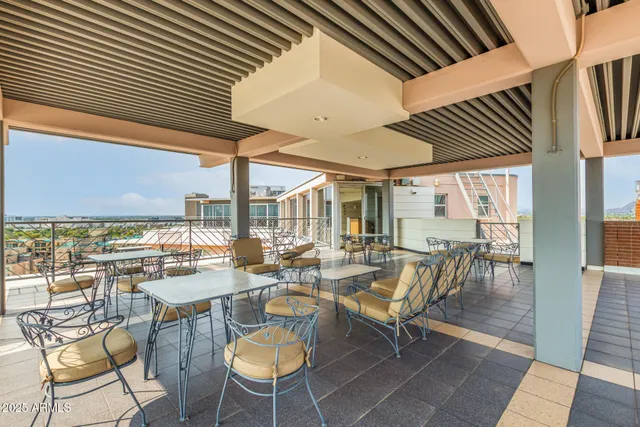 a view of a patio with a dining table chairs and balcony