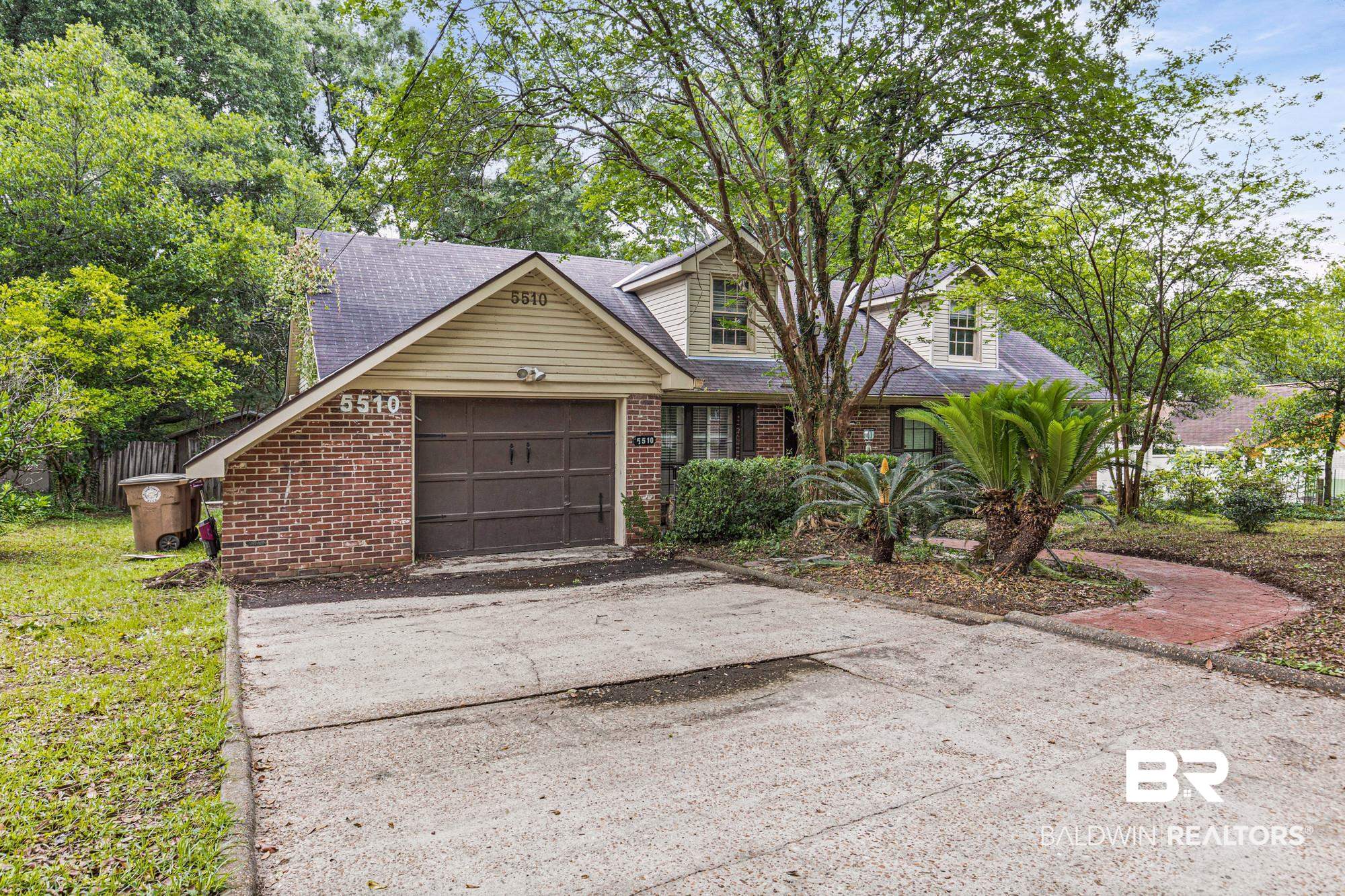 5510 Richmond Road Mobile, AL 36608 - Photo 3 of 21 Brick exterior featuring a two-car garage with a brown door, light siding, and a gabled roofline