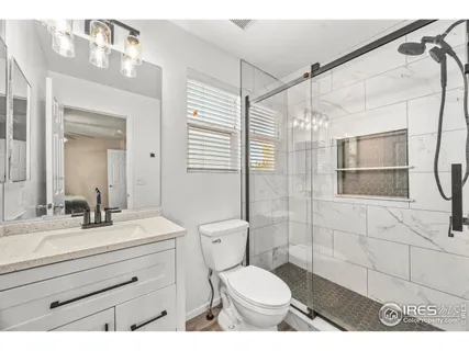 a bathroom with a sink toilet vanity and shower