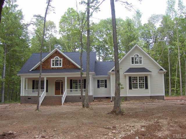 145 Oaks Lane Road Timberlake, NC 27583 - Photo 1 of 1 a front view of a house with a garden and trees