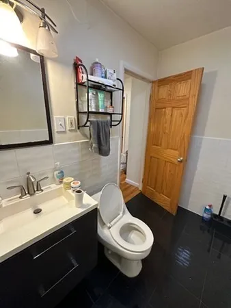 a bathroom with a toilet a sink a mirror a vanity and shower