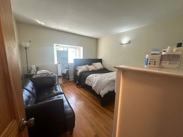 a bedroom with a bed and wooden floor