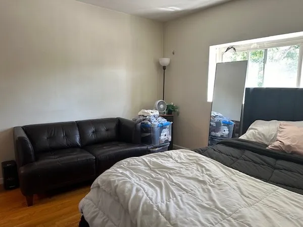 a bedroom with a bed and wooden floor