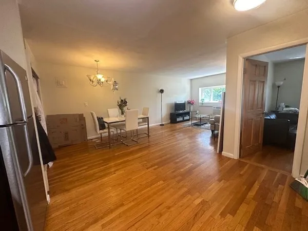 a view of a living room with furniture and wooden floor