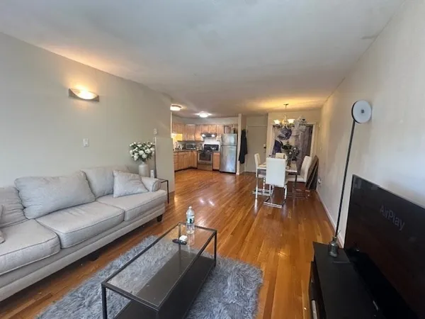 a living room with furniture and a wooden floor